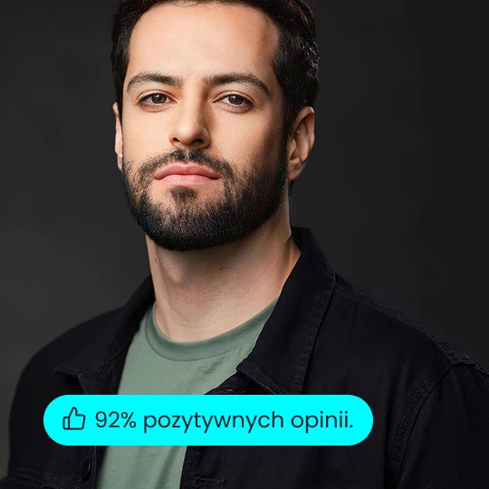 Formalny portret uśmiechniętego biznesmena w granatowej marynarce i koszuli na czarnym tle studia.